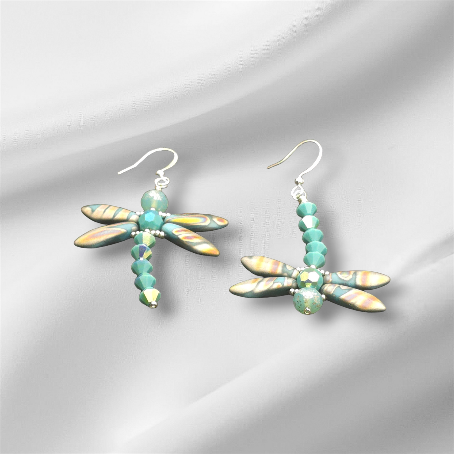 a pair of earrings with a dragon on it