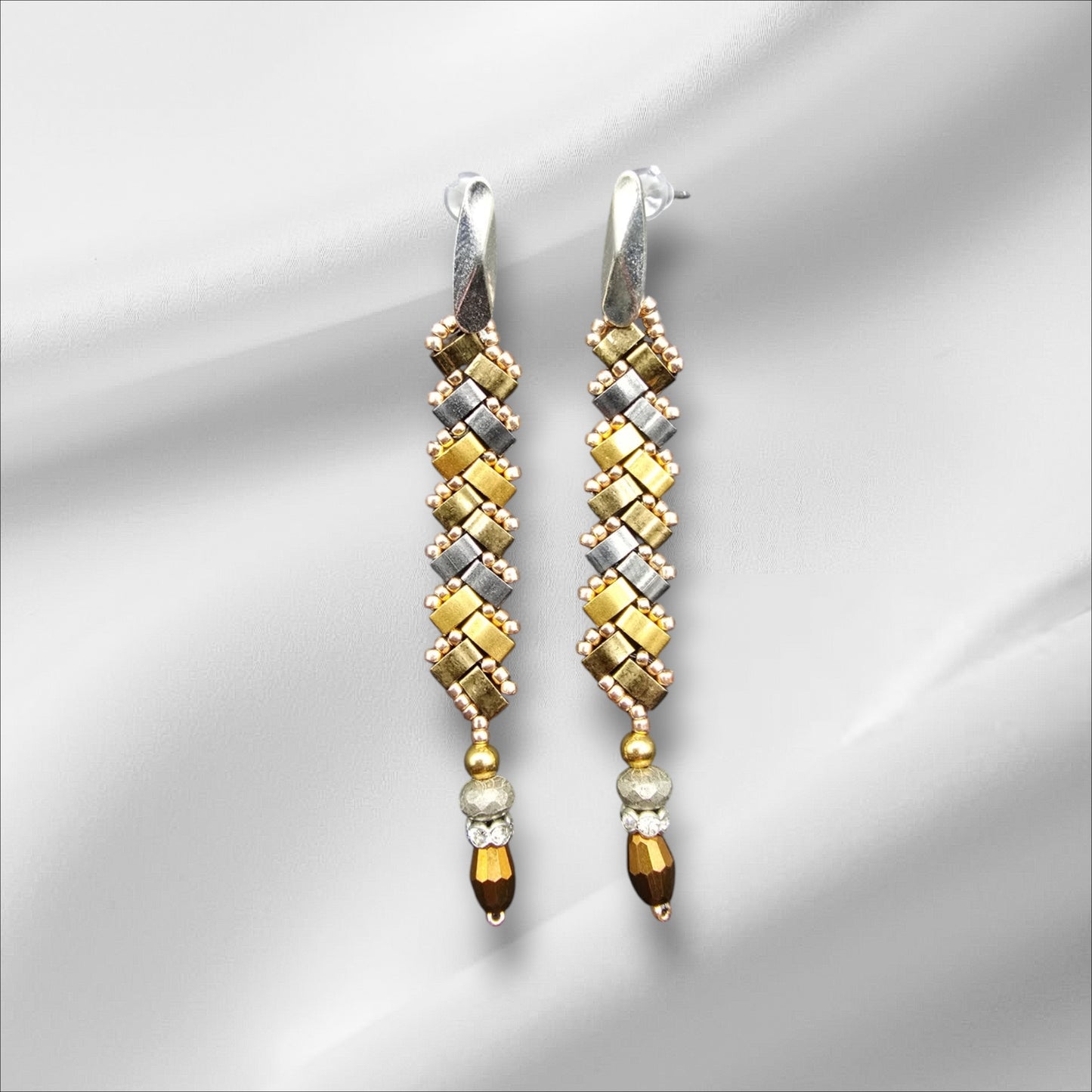 a pair of yellow and white earrings on a white background