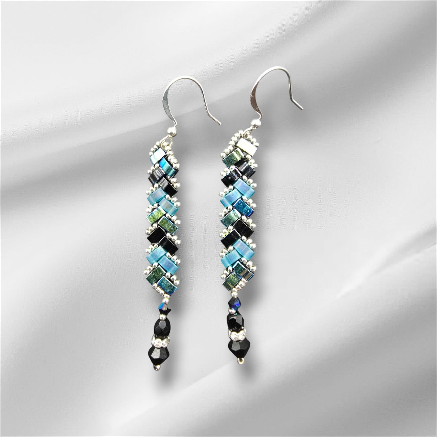 a pair of earrings on a white background