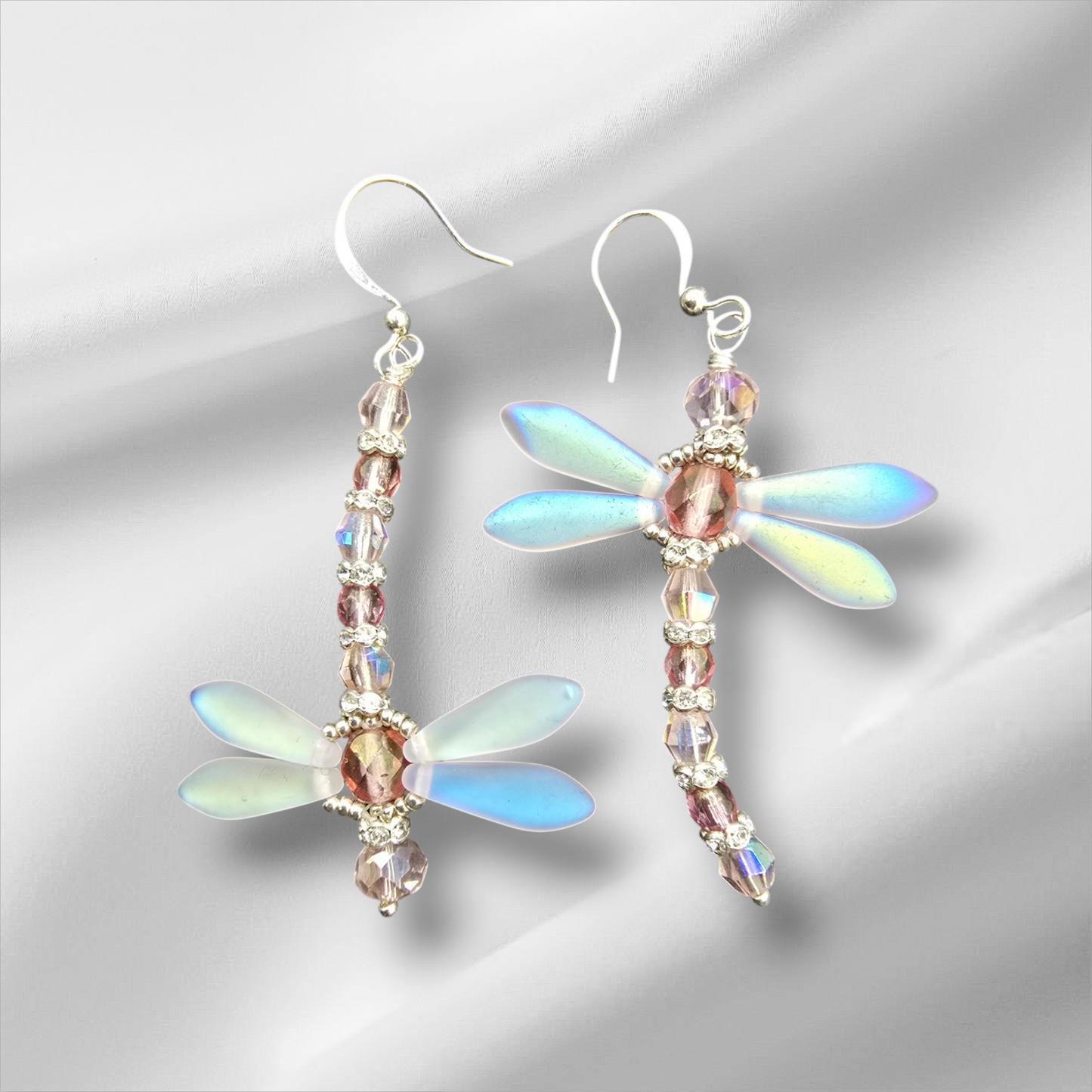 a pair of earrings with dragonflys on them