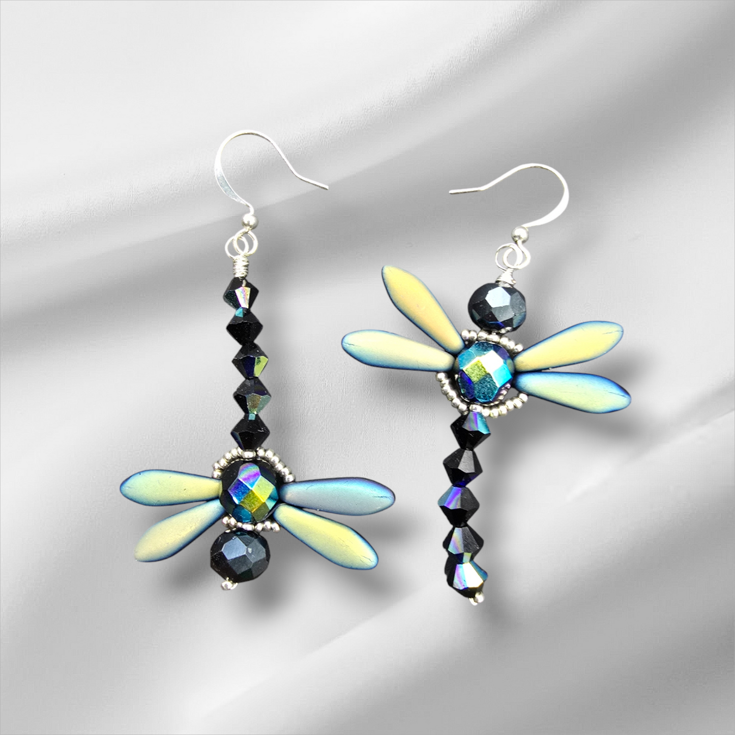 a pair of earrings with a dragonfly design