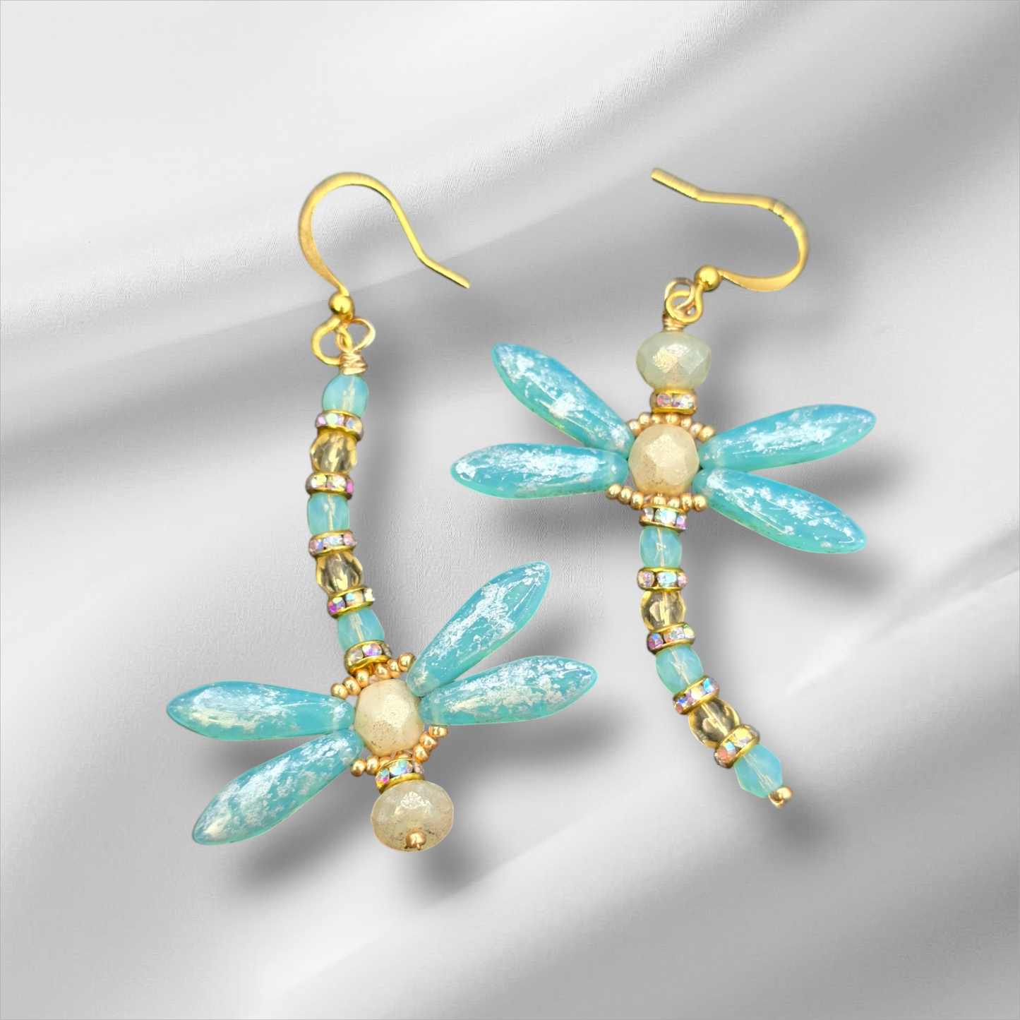 a pair of blue and gold dragonfly earrings