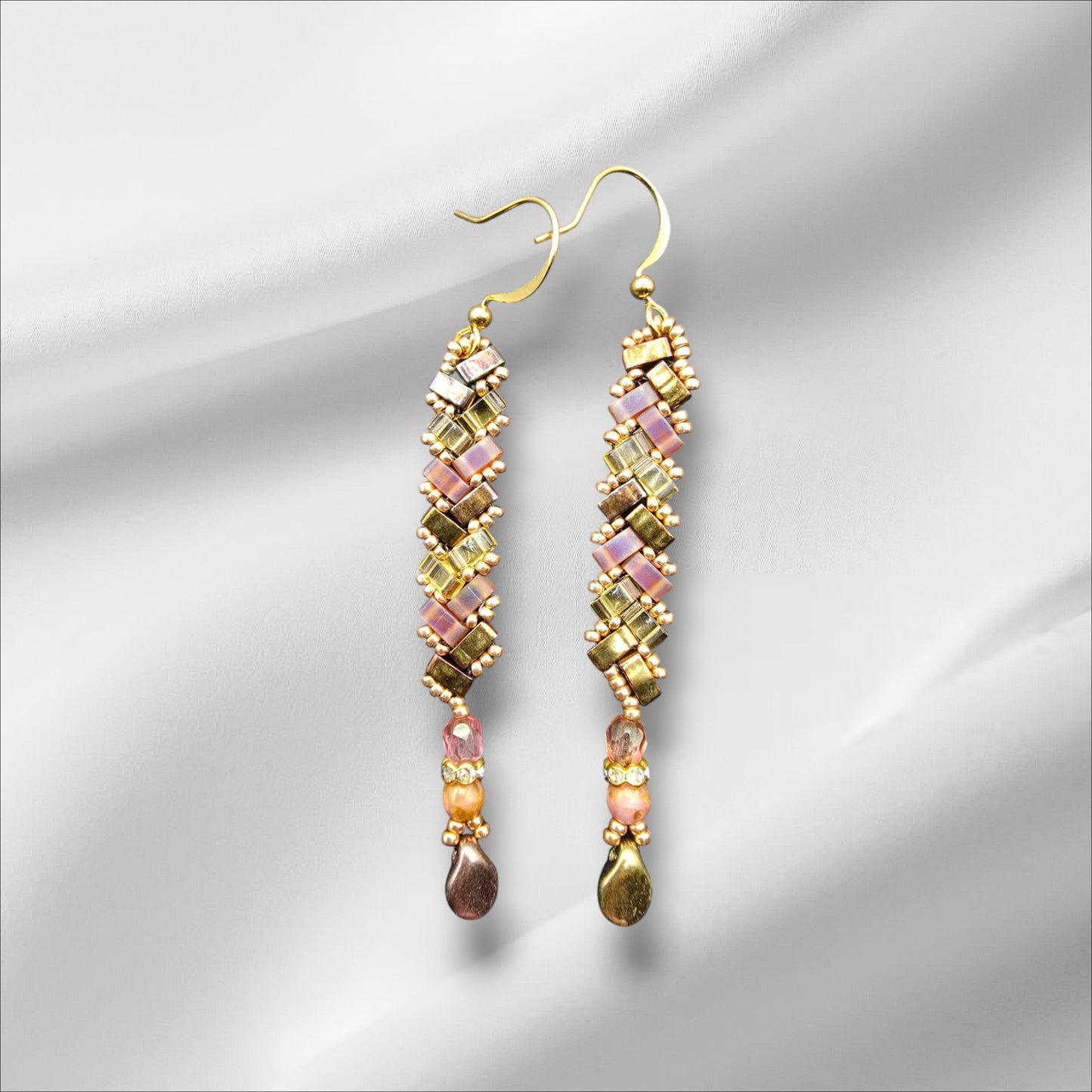 a pair of earrings on a white background