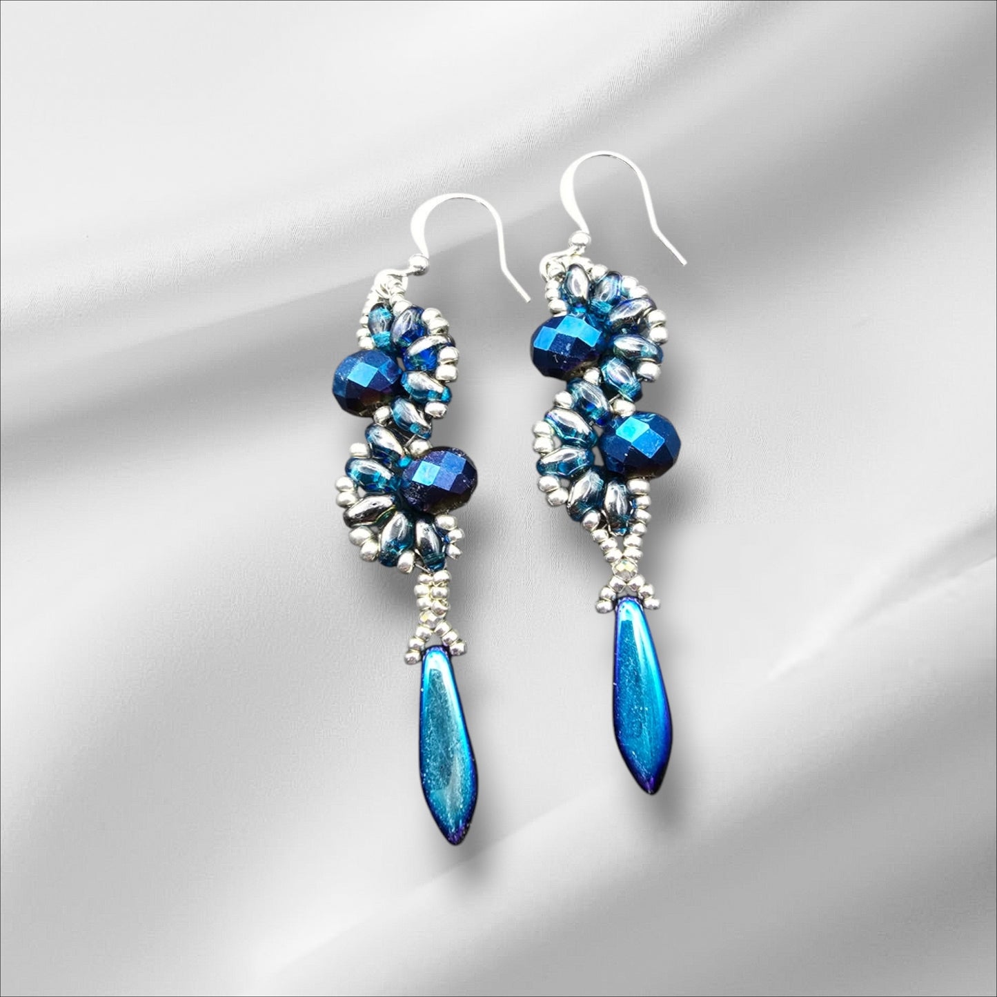 a pair of blue earrings on a white background