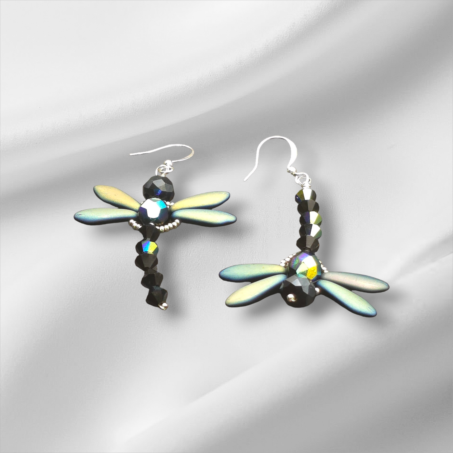 a pair of earrings with a dragonfly design