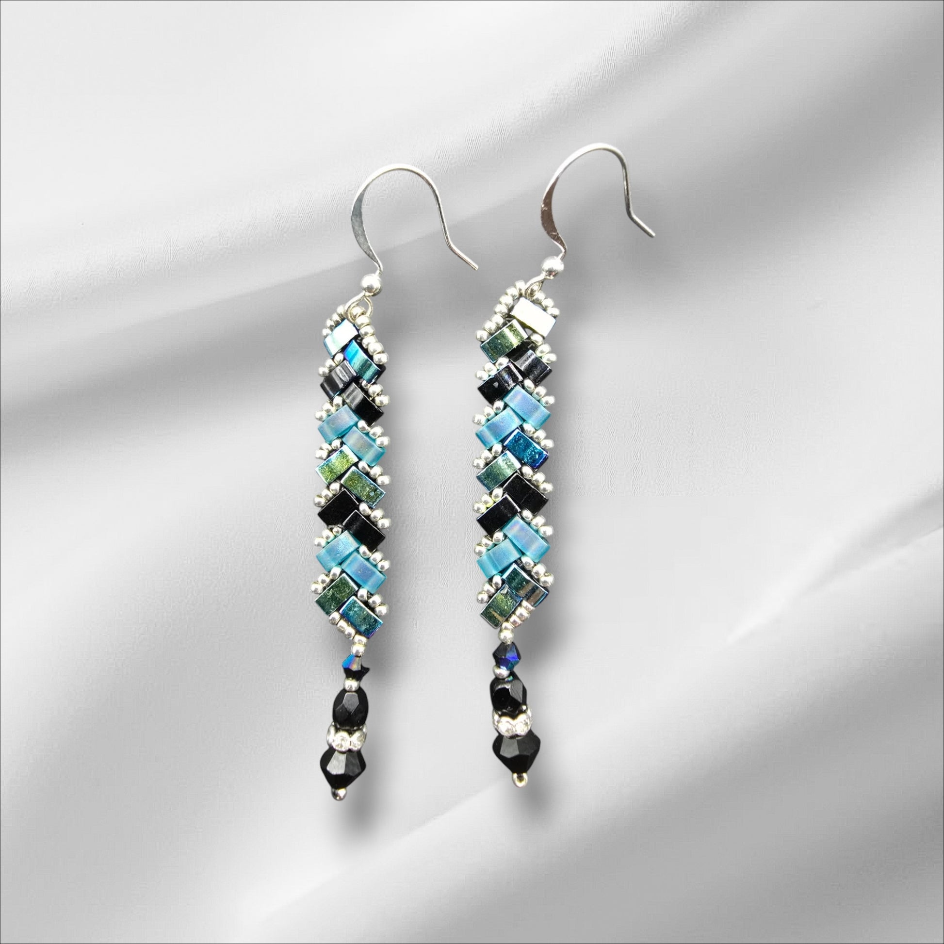 a pair of earrings on a white background
