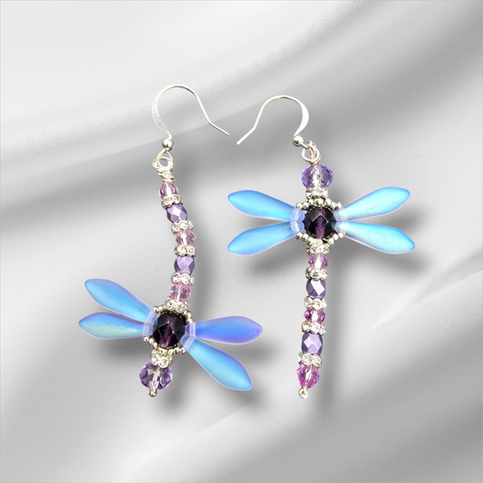 a pair of dragonfly earrings with purple and blue crystals