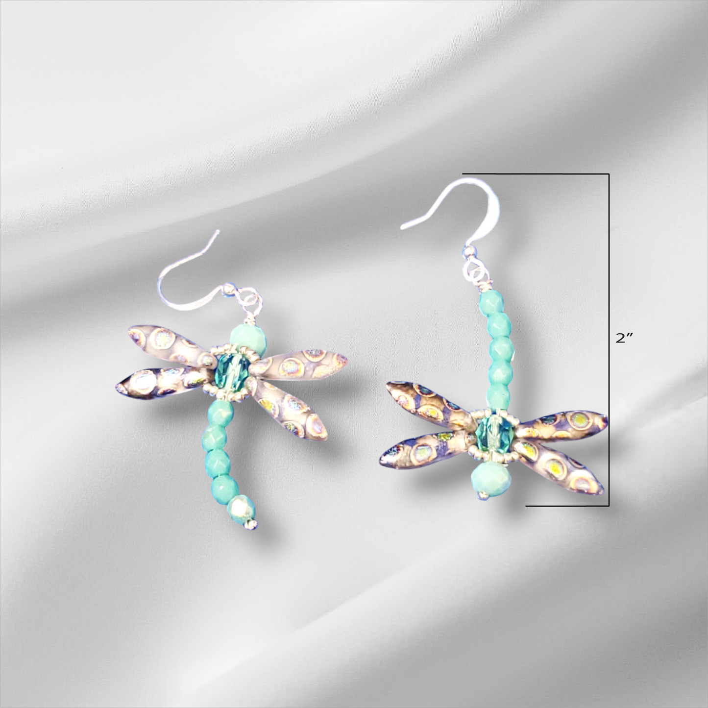 a pair of earrings with a dragonfly design