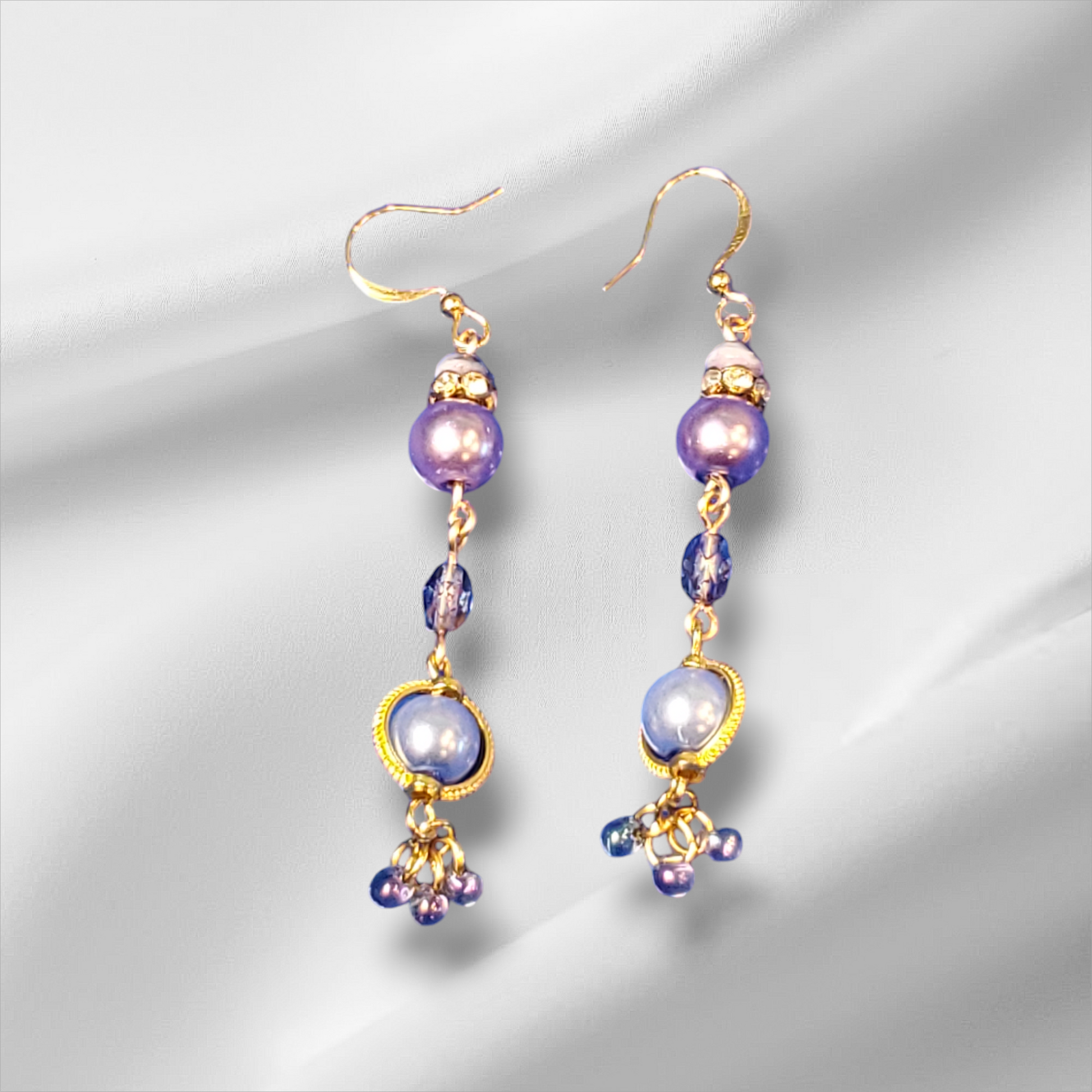 a pair of purple and gold earrings