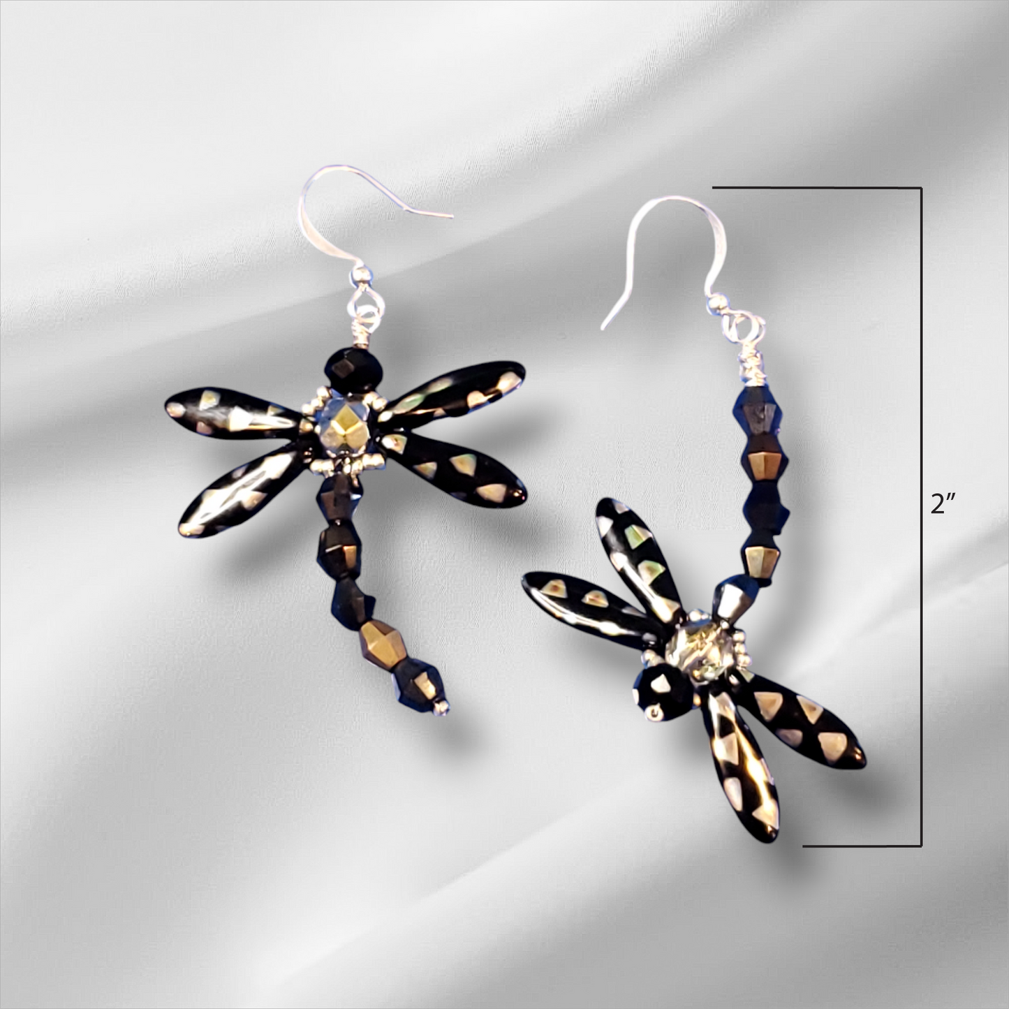 a pair of black and white dragonfly earrings