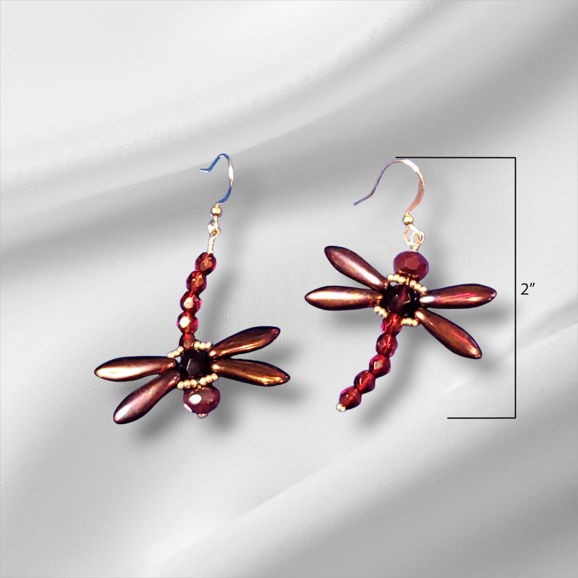 a pair of earrings with red beads on them