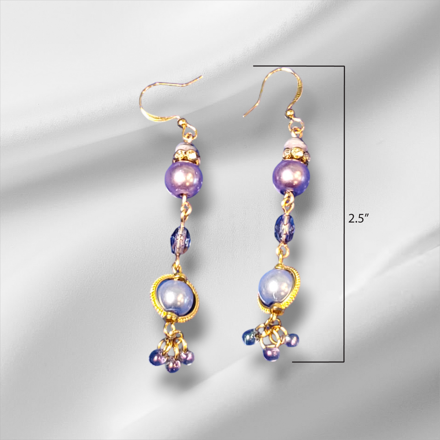 a pair of purple and gold earrings