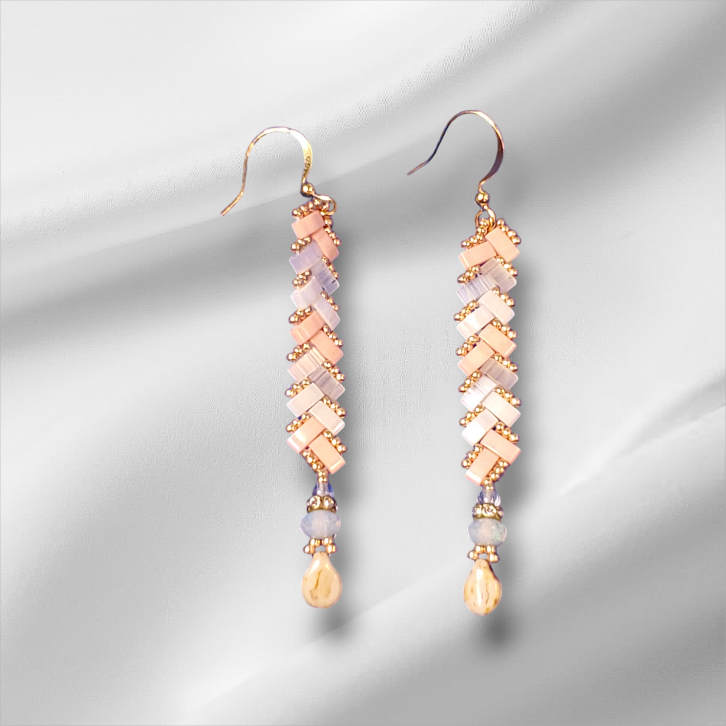 a pair of earrings on a white background