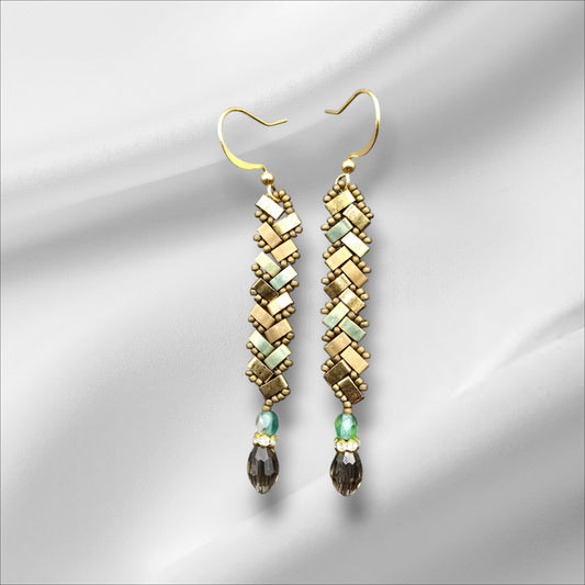 a pair of gold and green earrings